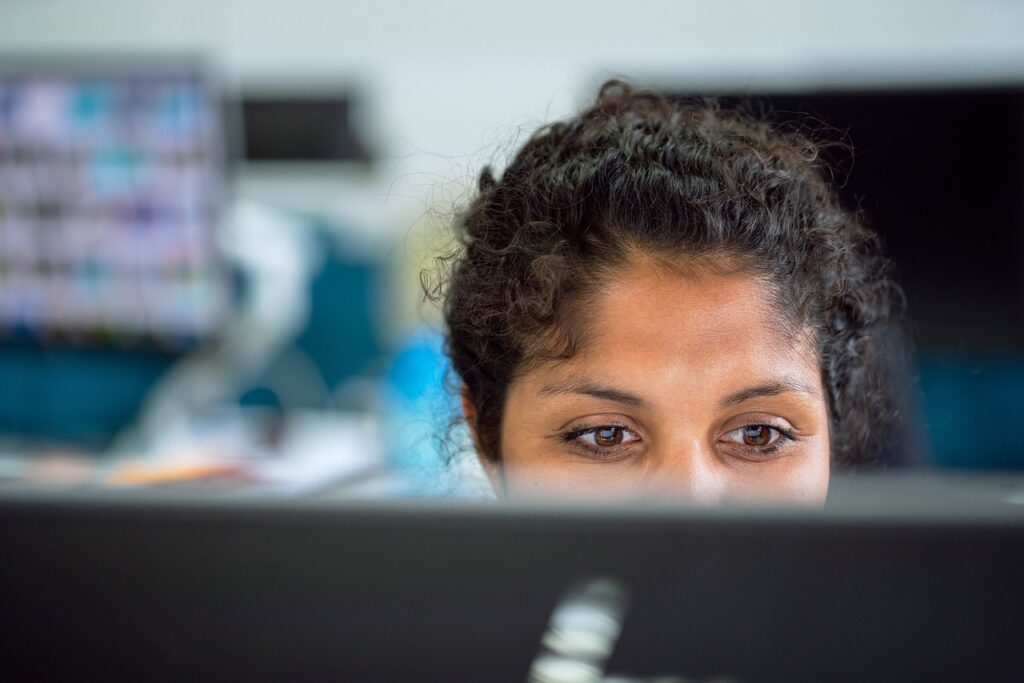 Office manager reviews a backup checklist beside a desktop computer and external drive.