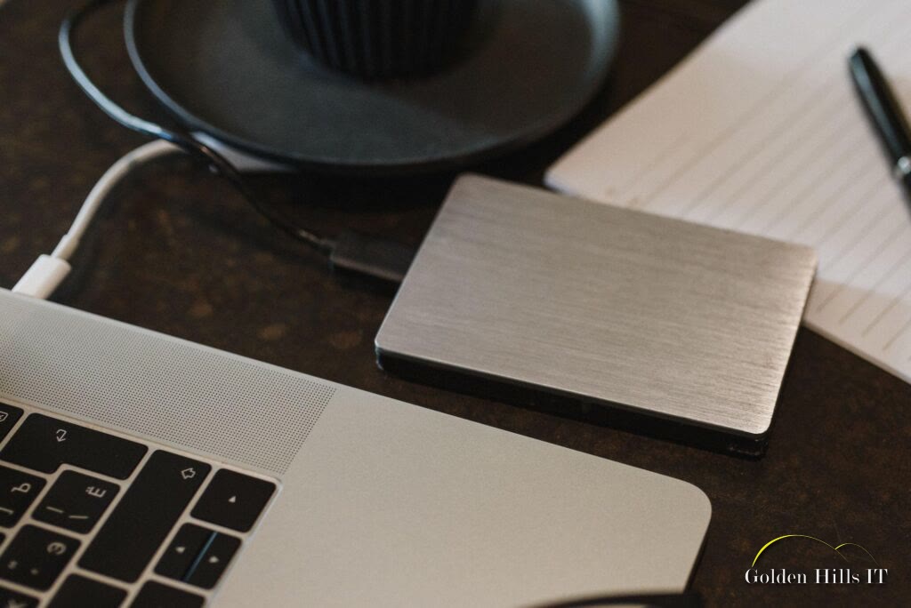 External hard drive connected to a laptop on a desk