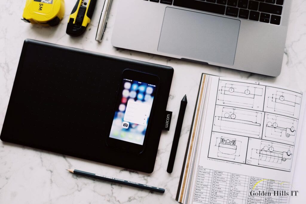 Workspace with laptop, smartphone, and technical drawings