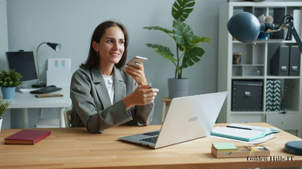 person in office holding phone and smiling at desk